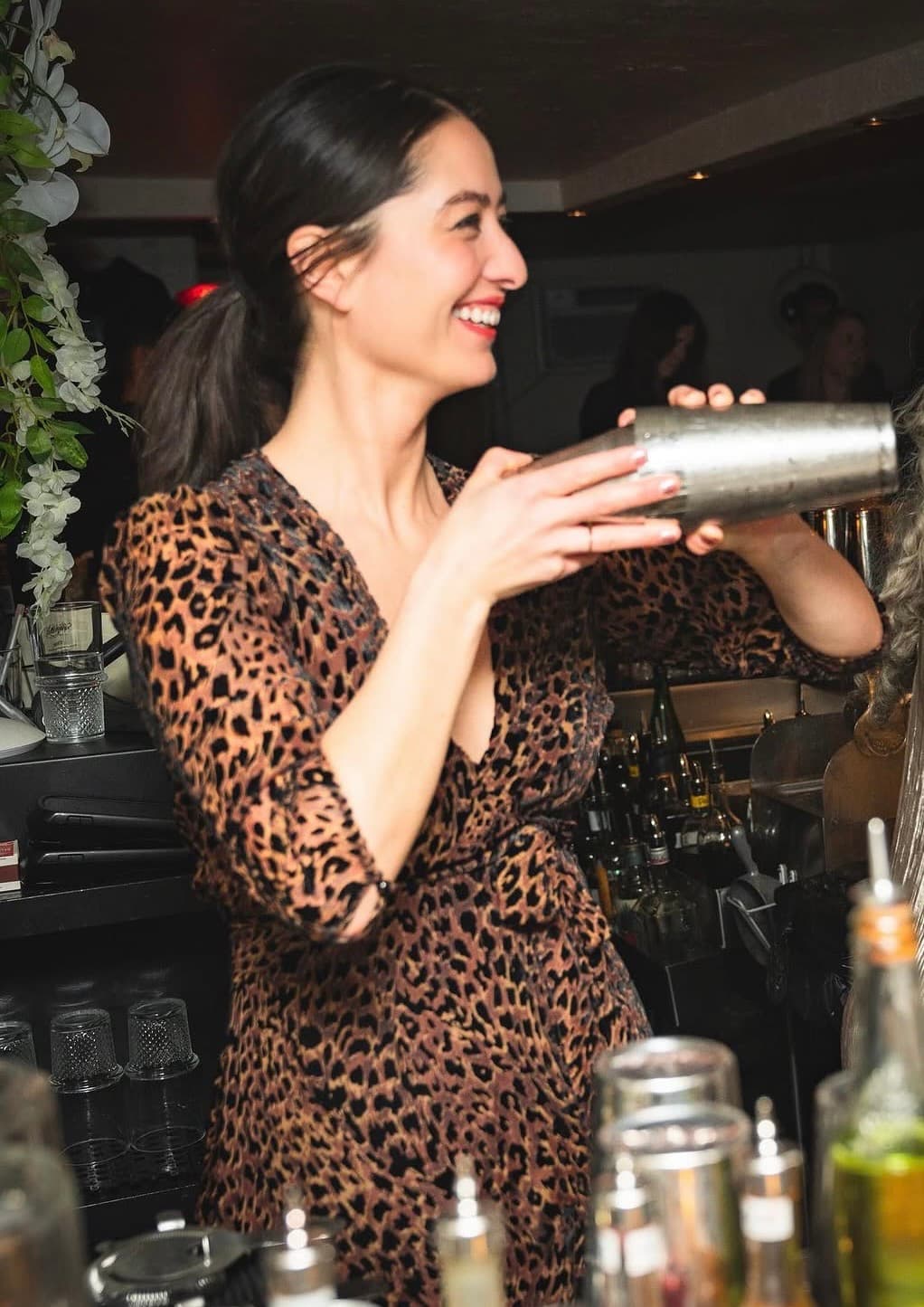 Natasha David smiling while making a cocktail
