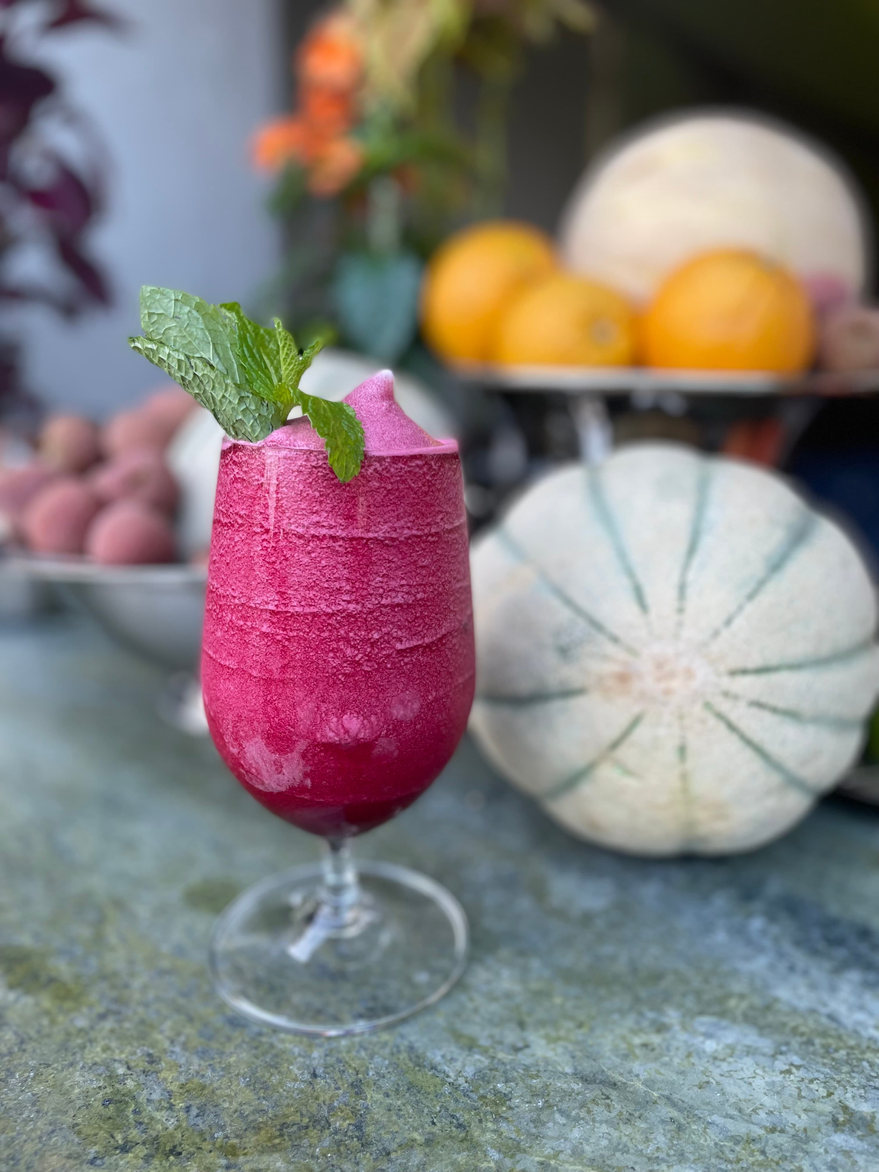 Magenta frozen cocktail garnished with fresh mint