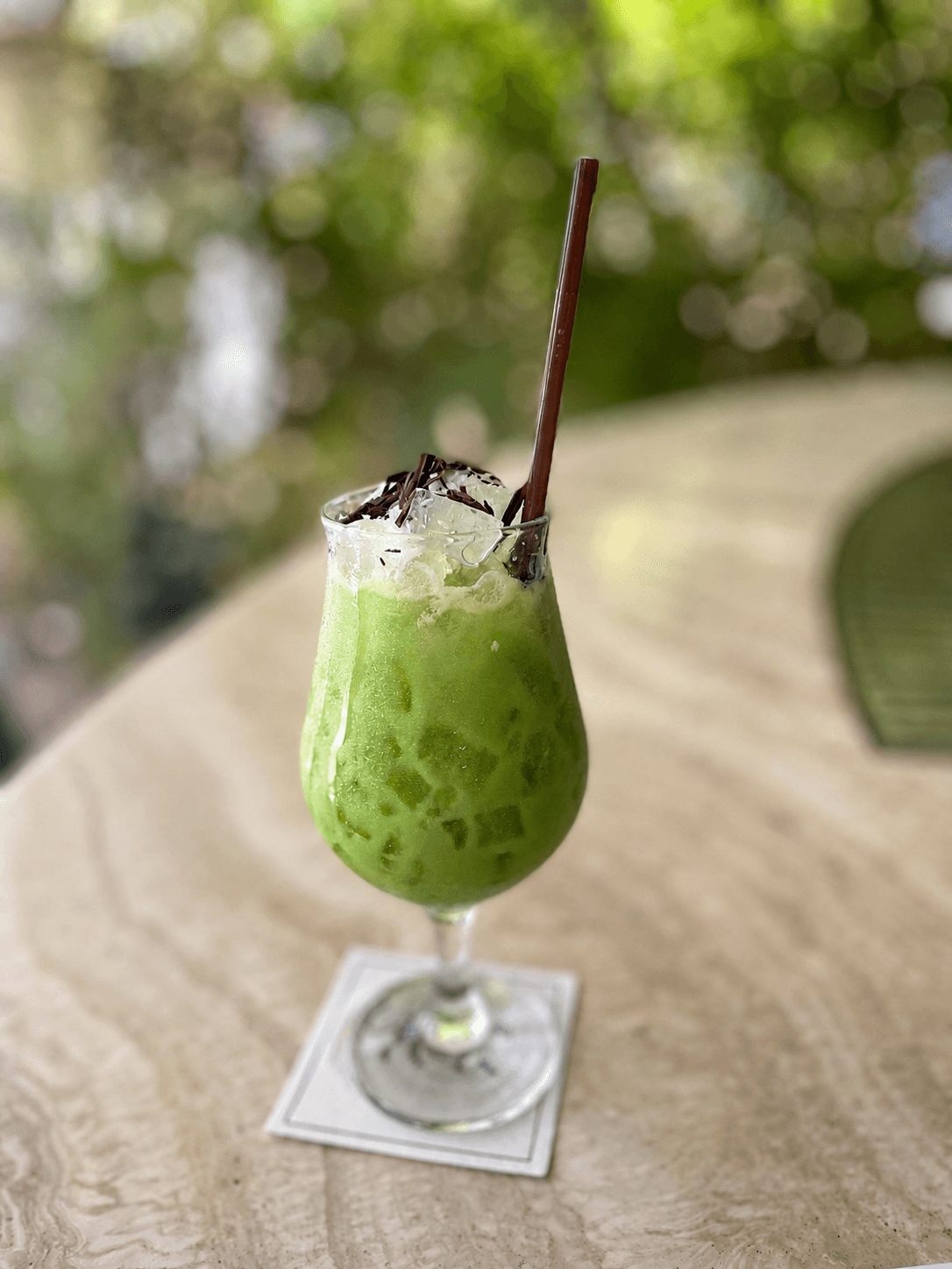 Green iced highball topped with cream and chocolate shavings
