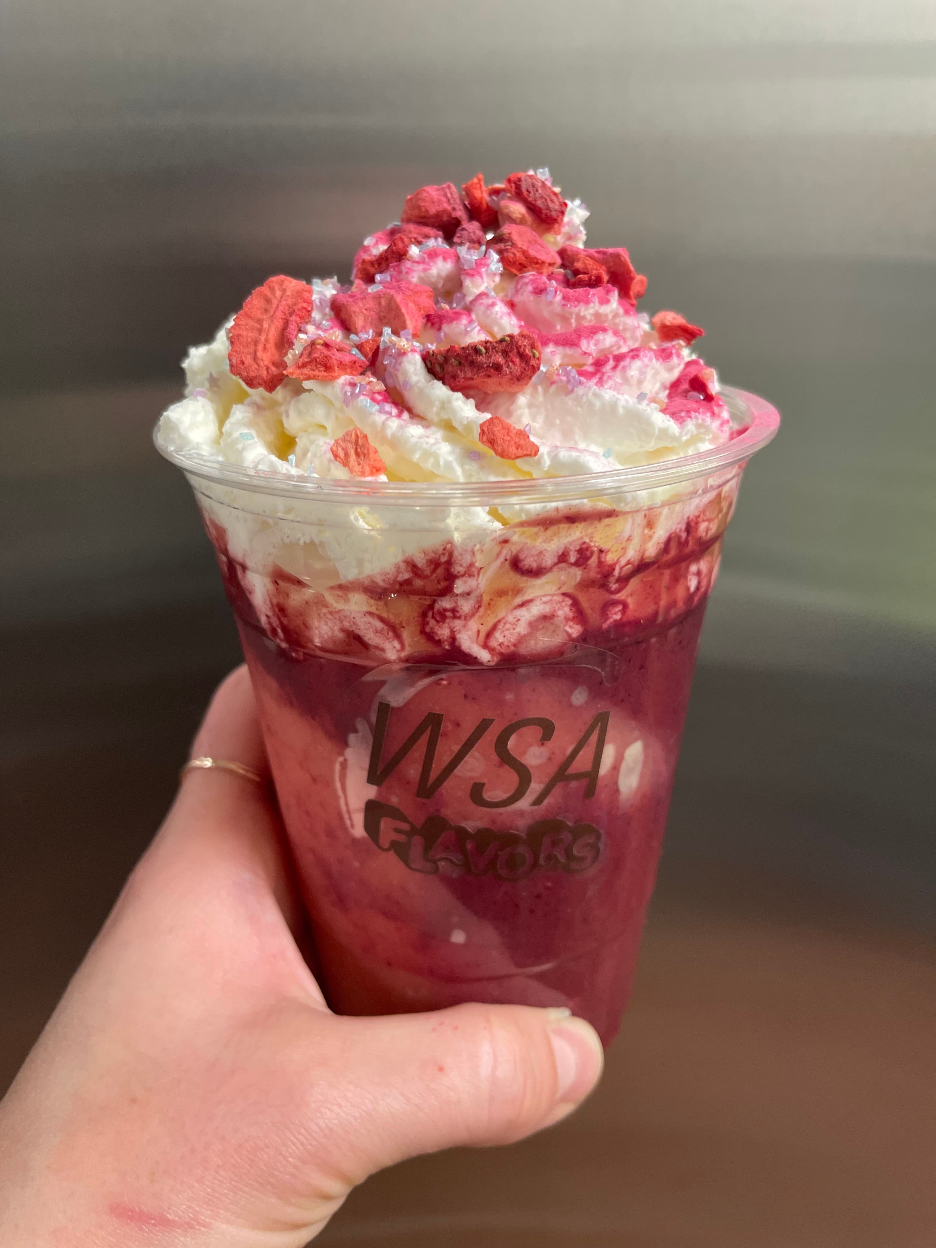 Bright berry drink topped with whipped cream and dried fruit