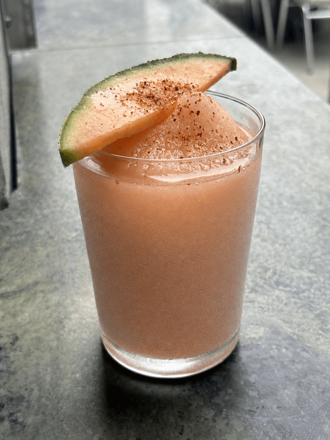 Frozen melon cocktail garnished with a spiced cantaloupe slice