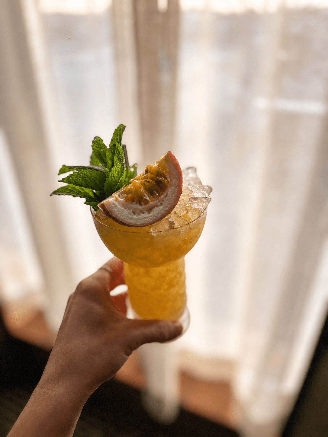 Crushed-ice cocktail garnished with passion fruit and mint
