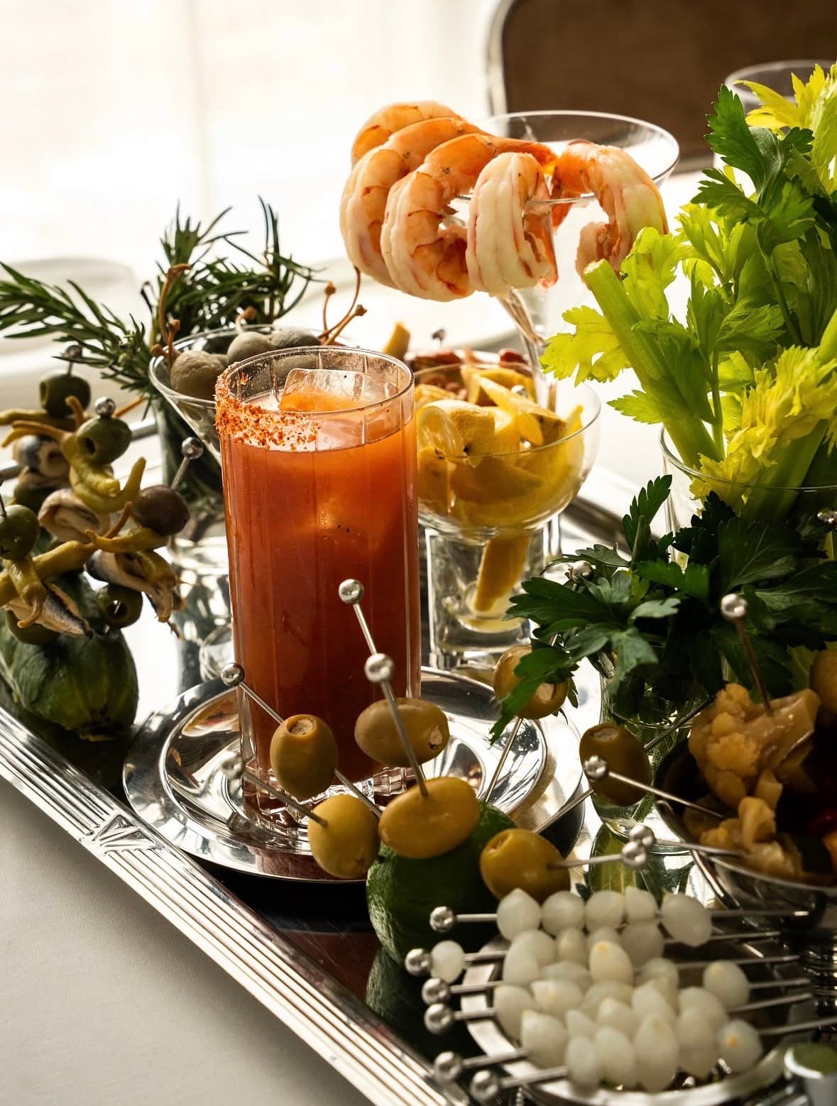 Bloody Mary and seafood garnish arrangement on a silver cart