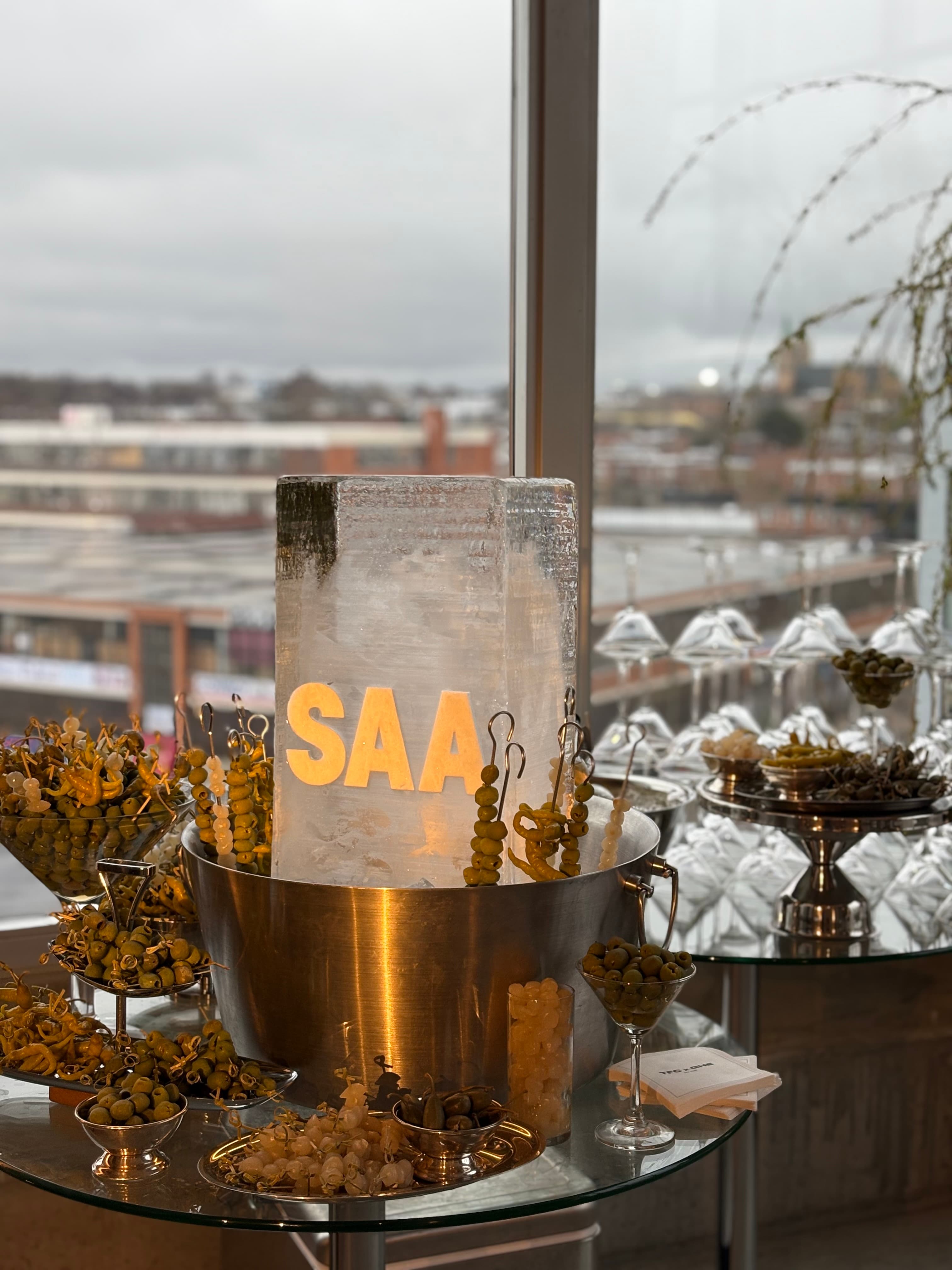 Olive garnish installation surrounding an illuminated SAA ice block